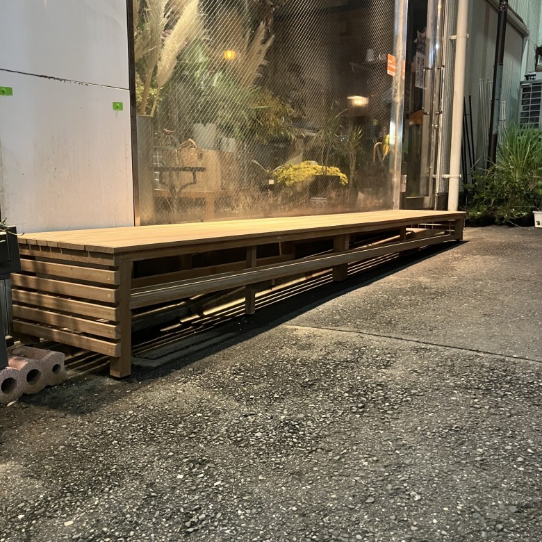 店舗のガラス面に沿って製作された、天然木のディスプレイ用デッキスペース